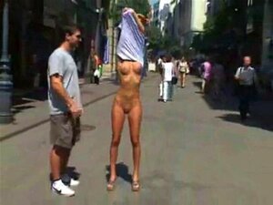 Девојка стоји потпуно гола на јавној улици. Девојка стоји потпуно гола на јавној улици
