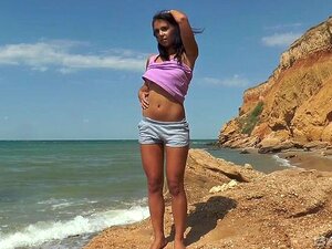 Magdeline Siada Na Szortach, By Się Masturbować Na Skalistym Brzegu