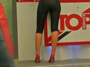 Ihana Blondi Tiukalla Perseellä Kuvattiin Ostoskeskuksessa, Hänen Täytyy Olla Muotimalli Kauniilla Pitkillä Ja Hoikilla Jaloillaan. Mimmi Käyttää Tiukkoja Shortseja Ja Tämä Tekee Hänestä Entistä Kuumamman Ja Seksikkäämmän. Kaikki Ihmiset Ympärillä Synkist